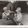 Pouring water into radiator of migrant's car in the streets of Muskogee, where family has stopped to say goodbye to their friends in that town. Oklahoma
