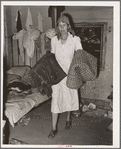 Mrs. Elmer Thomas, migrant to California, taking the blankets for packing into truck enroute to California from Muskogee, Oklahoma