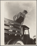 Elmer Thomas, migrant to California, standing on the body of his improvised truck before leaving for California. Near Muskogee, Oklahoma