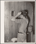 Migrant boy combing his hair at his home near Muskogee, Oklahoma