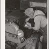 Elmer Thomas, migrant to California, pouring oil into engine preparatory for departure to California. Oklahoma