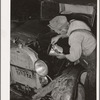 Elmer Thomas, migrant to California, pouring oil into engine preparatory for departure to California. Oklahoma