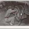 Tightening the rear wheel on truck which will carry migrant family to California from Muskogee, Oklahoma