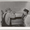 Migrant man and woman at rear of their truck before departure for California from Muskogee, Oklahoma