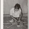 Packing the little odds and ends in small box, preparatory for leaving for California from Muskogee, Oklahoma