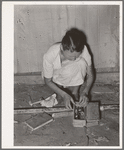 Packing the little odds and ends in small box, preparatory for leaving for California from Muskogee, Oklahoma