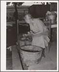 Wife of tenant farmer living near Muskogee picking over tomatoes before peeling for canning. Refer to general caption number 20
