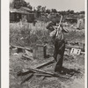 Boy living in Mays Avenue camp, Oklahoma City, Oklahoma, chopping wood. Refer to general caption no. 21