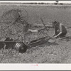 Son of tenant farmer near Muskogee, Oklahoma, working on disc harrow with rake in background. Refer to general caption no. 20