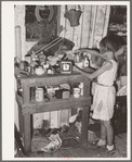 Child at cluttered table in shack home in Mays Avenue camp. Oklahoma City, Oklahoma