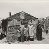 Family in front of shack home, Mays Avenue camp. Oklahoma City, Oklahoma