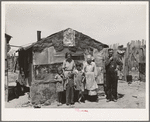 Family in front of shack home, Mays Avenue camp. Oklahoma City, Oklahoma