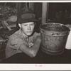 Boy sitting at table in his shack home near Mays Avenue camp. Oklahoma City, Oklahoma