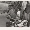 Boy living in camp near Mays Avenue making sandwich. This food is distributed by Saint Anthony's hospital after patients have been fed. This is the only foodline left in Oklahoma City, Oklahoma