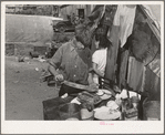 Boy living in camp near Mays Avenue making sandwich. This food is distributed by Saint Anthony's hospital after patients have been fed. This is the only foodline left in Oklahoma City, Oklahoma