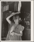 Little girl combing hair. She lives in camp near Mays Avenue. Oklahoma City, Oklahoma