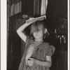 Little girl combing hair. She lives in camp near Mays Avenue. Oklahoma City, Oklahoma
