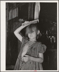 Little girl combing hair. She lives in camp near Mays Avenue. Oklahoma City, Oklahoma