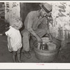 Resident of Mays Avenue camp under the bridge, covering milk with wet cloth in order to keep it cool. Many residents of this camp sneak into stockyards early in the morning to milk cows