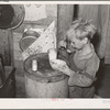 Child in Mays Avenue camp, Oklahoma City, Oklahoma, eating an overripe canteloupe found in market