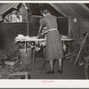 Woman ironing in tent home. Community camp, Oklahoma City, Oklahoma