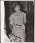 Wife of tenant farmer slicing fatback for noonday meal near Muskogee, Oklahoma
