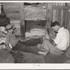 Resident of Mays Avenue camp, Oklahoma City, Oklahoma, taking piece of glass out of boy's foot