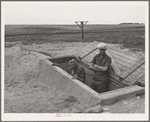 Mr. Shoenfeldt and son, FSA (Farm Security Administration) client in Sheridan County, Kansas, at entrance to fruit cellar which they built for six dollars and twenty cents