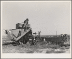 Old combine which has not been used for several years. Gray County, Kansas