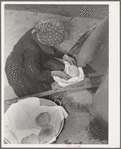 Spanish-American woman removing freshly baked bread from outdoor earthen oven near Taos, New Mexico