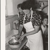 Spanish-American woman peeling peppers after the skins were loosened by heating on top of stove. Near Taos, New Mexico