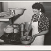 Spanish-American woman removing peppers from stove. Taos, New Mexico