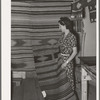 WPA (Works Progress Administartion/Work Projects Administration) project supervisor displaying some of the articles made at her weaving project. Costilla, New Mexico
