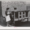 Spanish-American FSA (Farm Security Administration) client feeding her rabbits near Taos, New Mexico