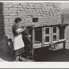 Spanish-American FSA (Farm Security Administration) client feeding her rabbits near Taos, New Mexico