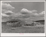 Barn covered with hay and haystacks near Taos, New Mexico