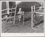 Son of FSA (Farm Security Administration) client going through gate made of old wagon wheel. Farm near Bradford, Vermont, Orange County