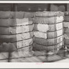 Bale of cotton linters and bale of middling cotton side by side in waarehouse. The bale of linter, on the side, left, is the fiber which is close to the seed. One of its major uses is the making of cellulose. Houston, Texas