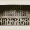 Chorus members standing in front of exterior Automat set in the stage production Face the Music