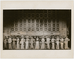 Chorus members standing in front of exterior Automat set in the stage production Face the Music