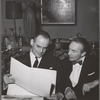 Lincoln Kirstein and George Balanchine seated on sofa looking at prints and designs