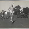 Ted Shawn dancing outdoors in midair jump as Delissaville residents watch



