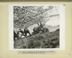 Under camoflage net, Polish gunners put up a barrage with one of the new medium caliber guns.