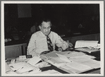 William L. Laurence working at desk