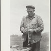 Sheepshearer cleans blade of his shears, Rosebud County, Montana