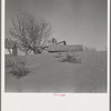 Large drifts of good Kansas top soil threaten to cover up this farmer's home. Kansas