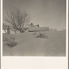 Large drifts of good Kansas top soil threaten to cover up this farmer's home. Kansas