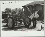 Farmer inspects a cultivator, Central Iowa 4-H Club fair, Marshalltown, Iowa