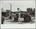 Farmer and family look at machinery on exhibition, Central Iowa 4-H Club fair, Marshalltown, Iowa