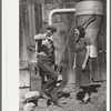 Elmo Temple, Chaffee County, Colorado rehabilitation client and his wife, Louise, pose beside a feed grinder which is an important part of their farm equipment